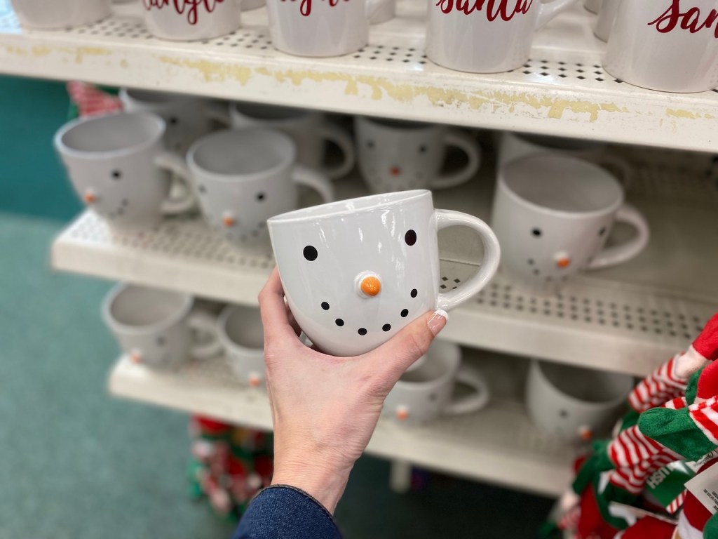 Hand holding cute snowman mug