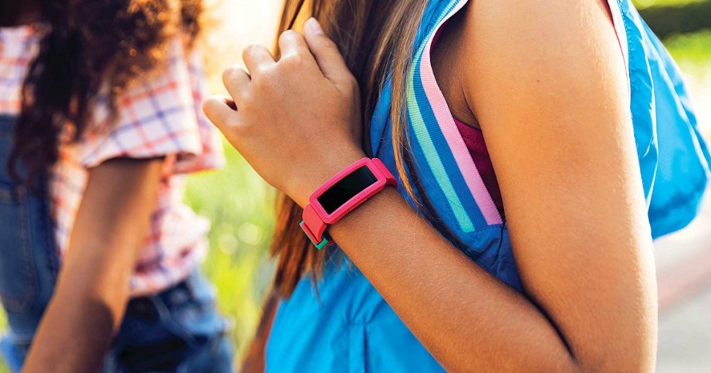 Girl wearing a pink kids activity tracker and backpack