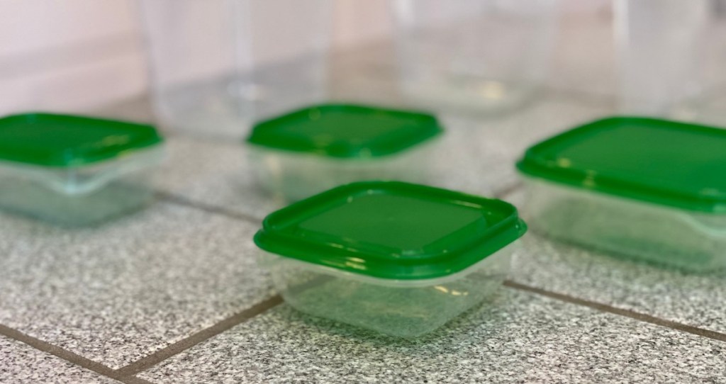 green and clear food containers sitting on gray tiled counter