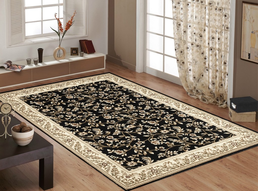Black and gold area rug on light hardwood flooring in living room