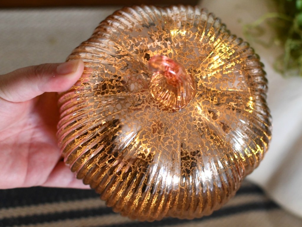 Gold Glass Light-Up Pumpkin in hand