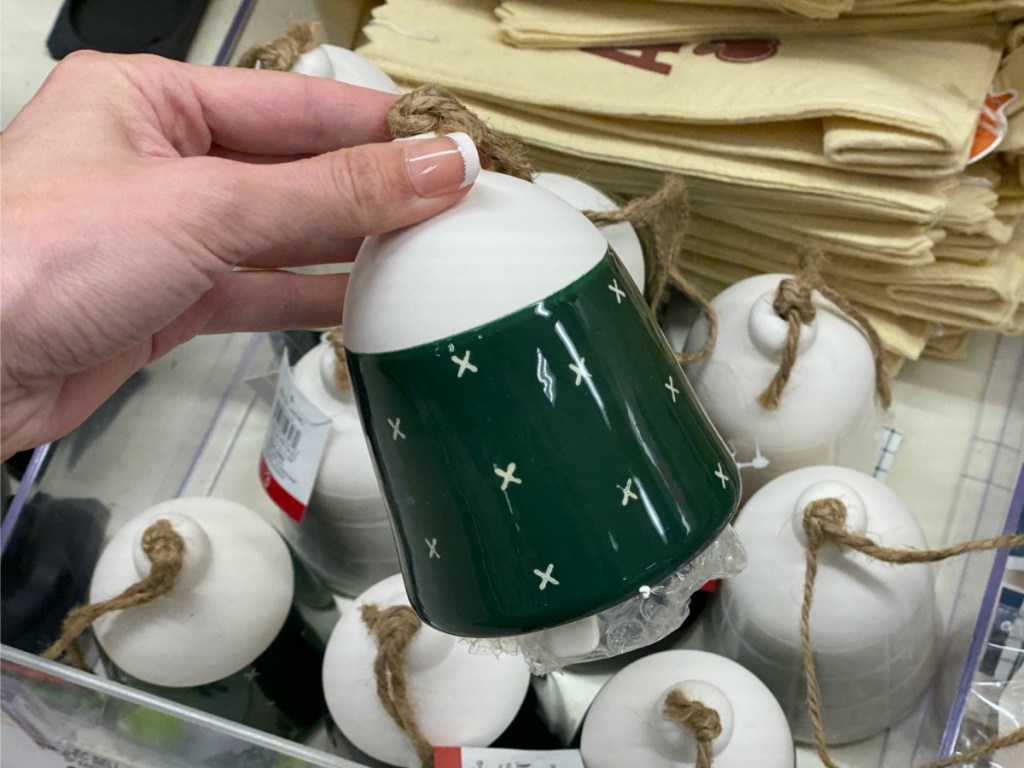 Hand holding a green ceramic bell