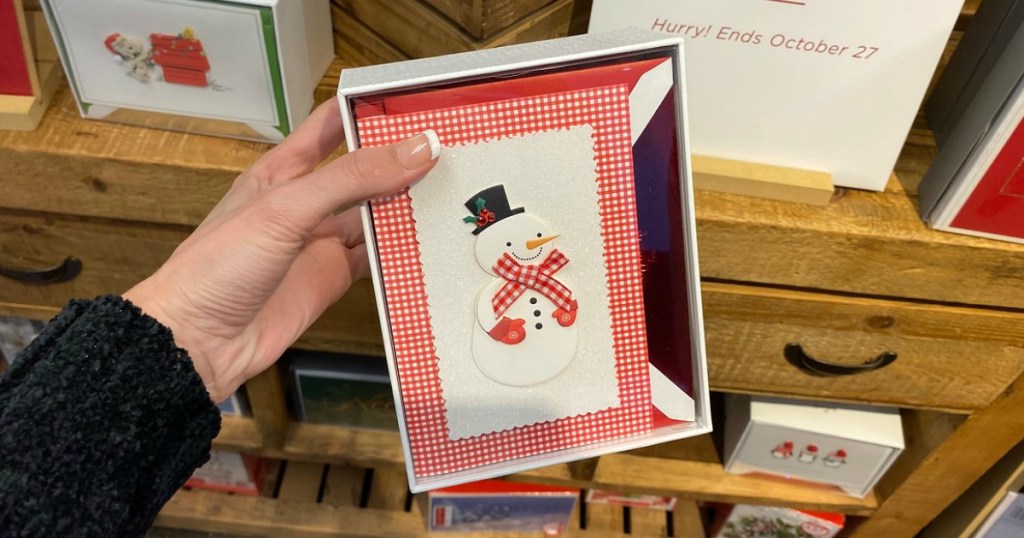 woman holding Hallmark Christmas card with snowman on the front