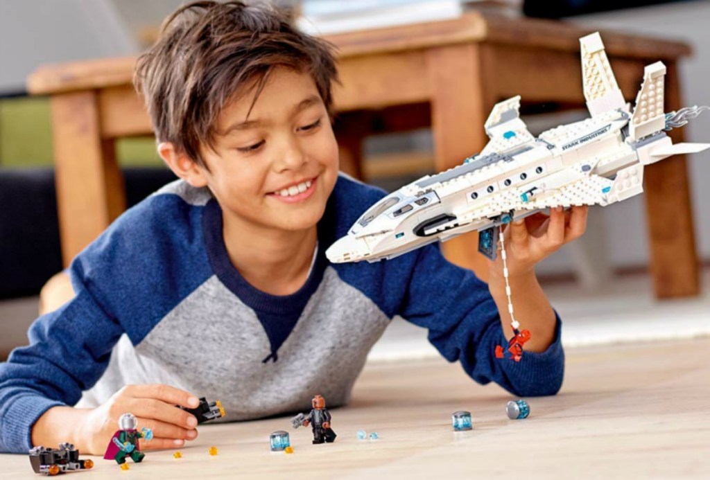 boy playing on carpet with LEGO Marvel Spider-Man Far From Home: Stark Jet and the Drone Attack Building Kit