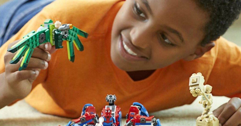 boy playing with LEGO spider-man toys