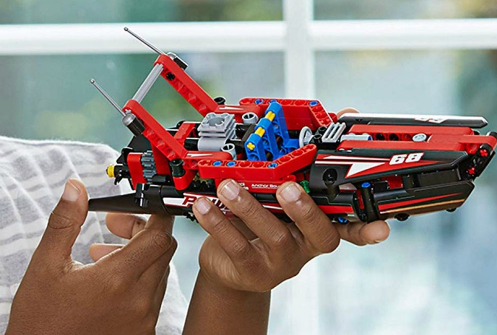 Kid playing with a LEGO Power Boat