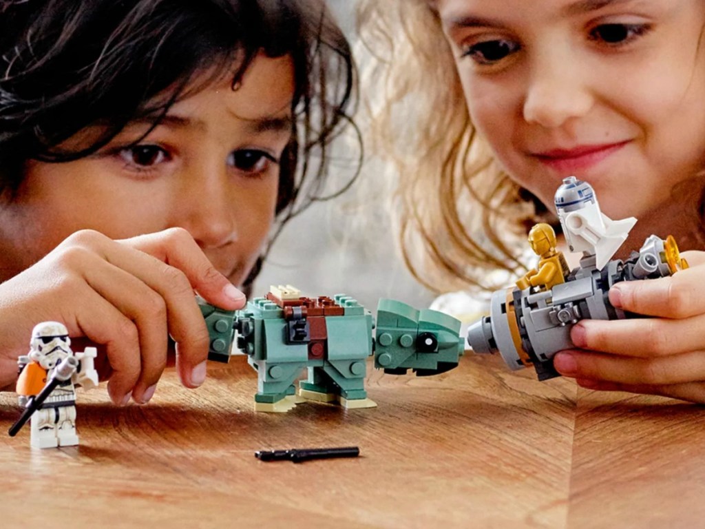 Boy and girl playing with a LEGO Star Wars play set