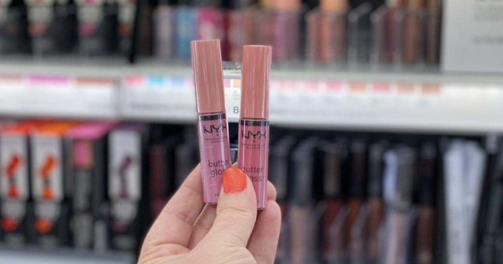 hand holding two NYX Cosmetics Butter Glosses