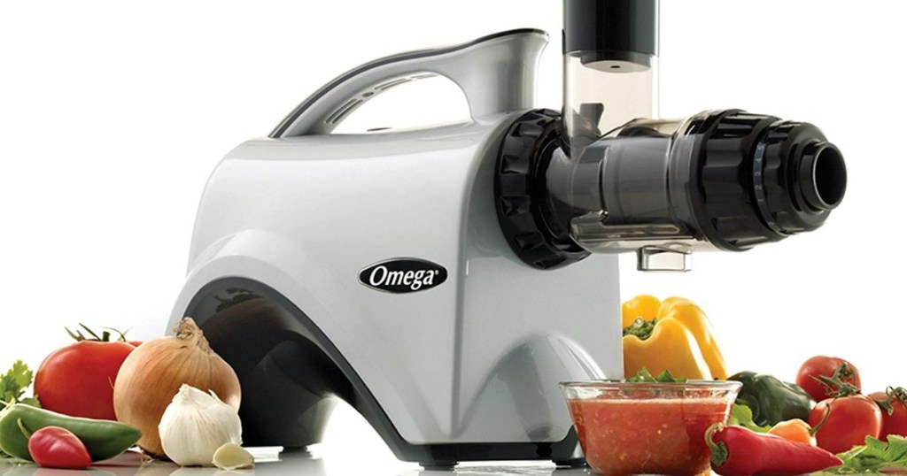 Omega Juicer Extractor and Nutrition Center surrounded by vegetables