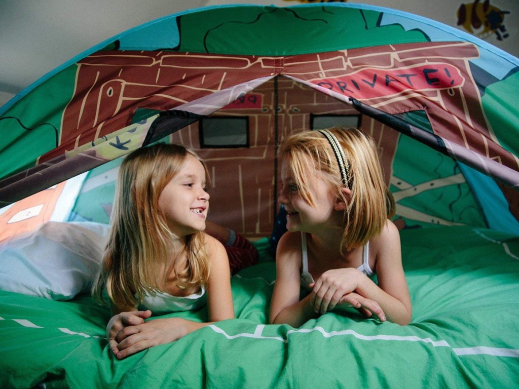 girls laying in play tent
