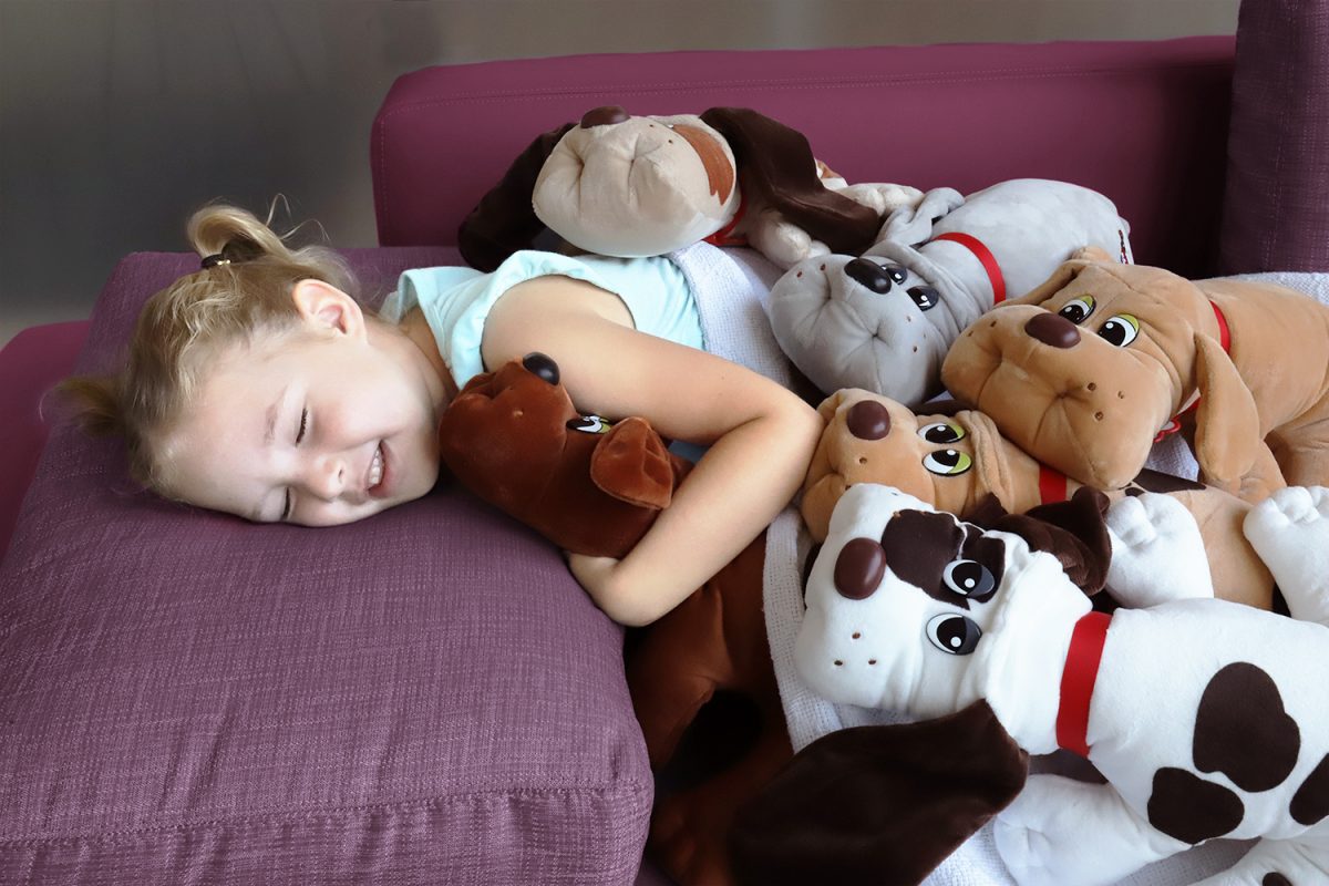 girl laying with Pound Puppies Plush