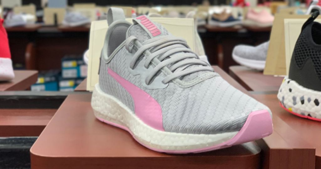 grey and pink puma shoes with a white sole on display in store