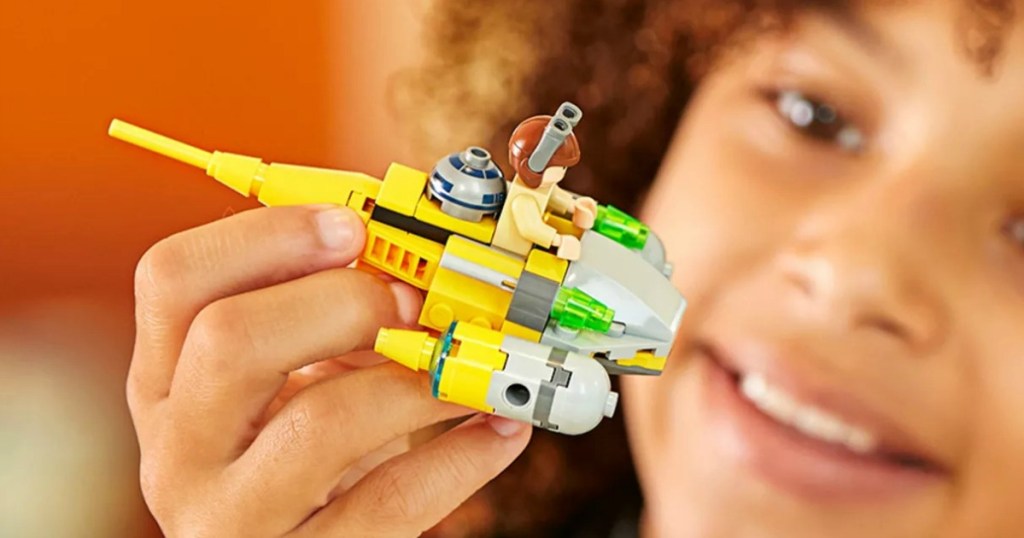 Child playing with a Star Wars LEGO Ship