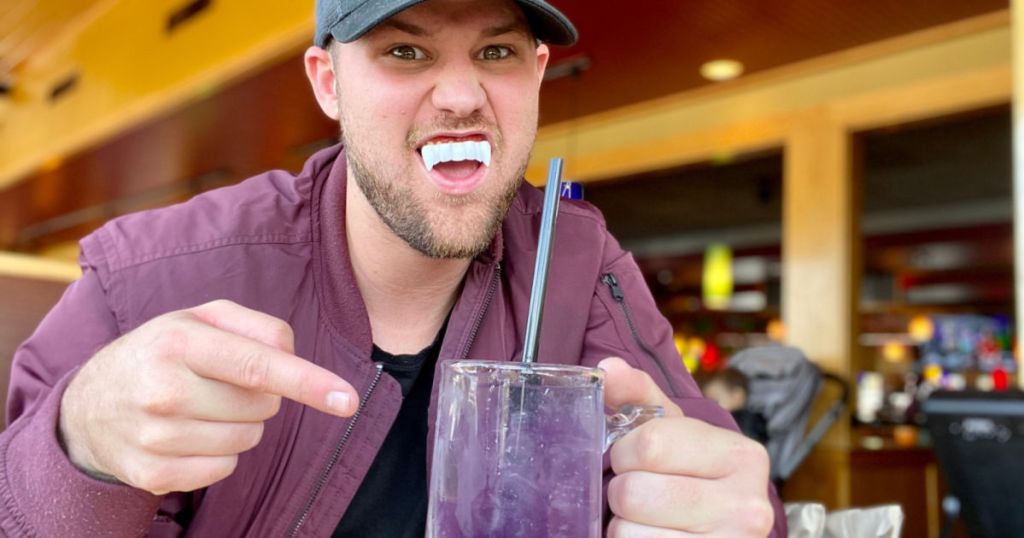 stetson wearing vampire fangs drinking purple drink at applebees