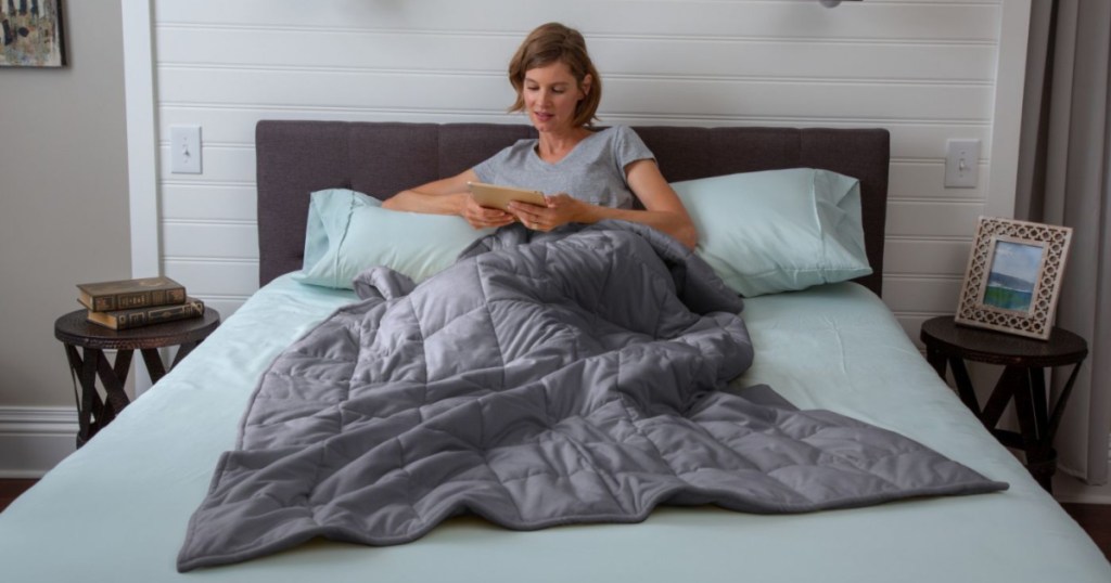 woman using gray tranquility weighted blanket on bed