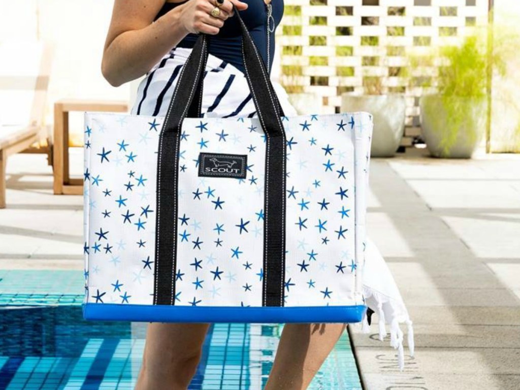 woman by pool holding tote