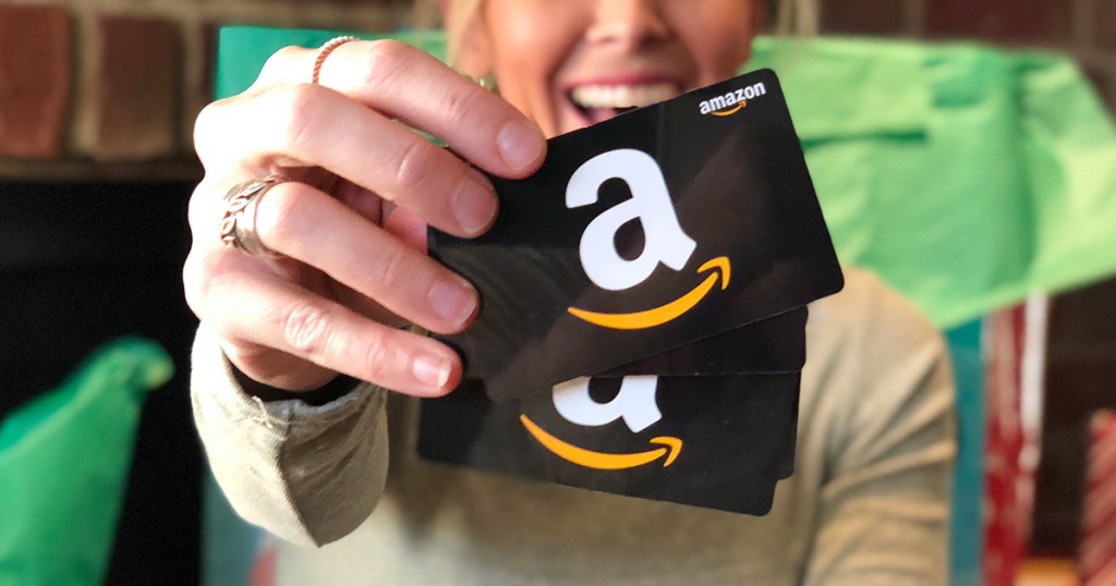 woman holding up Amazon gift cards