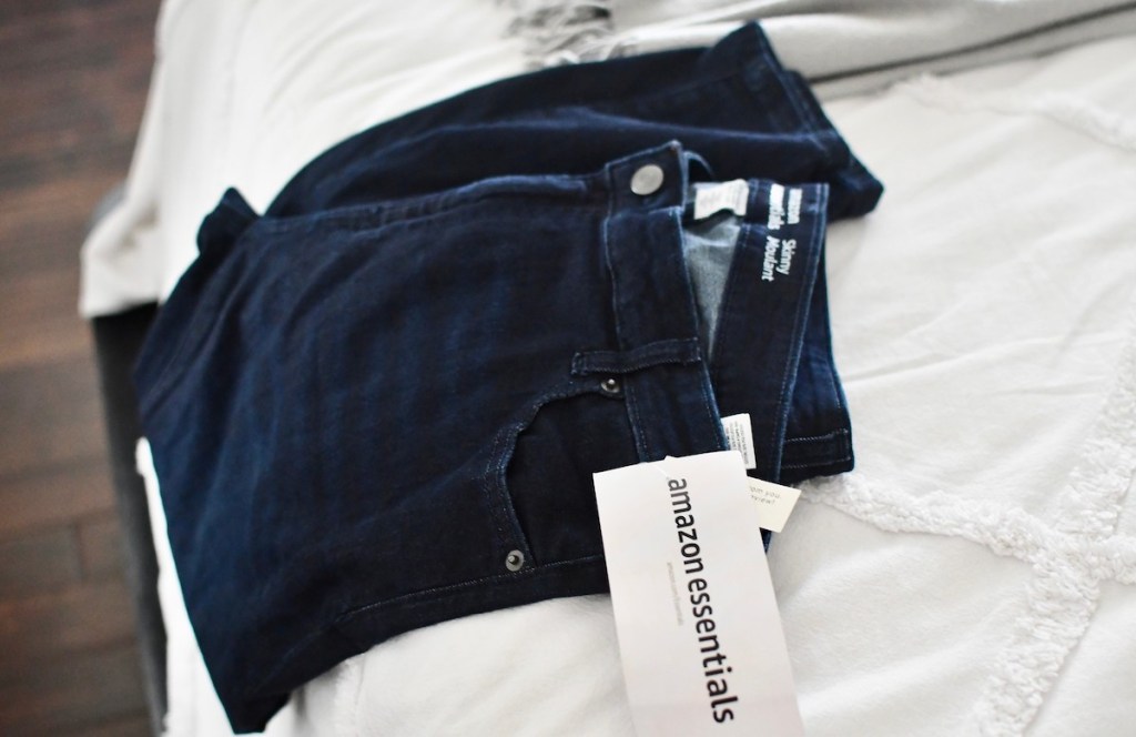 dark wash jeans laying on bed with amazon essentials tag