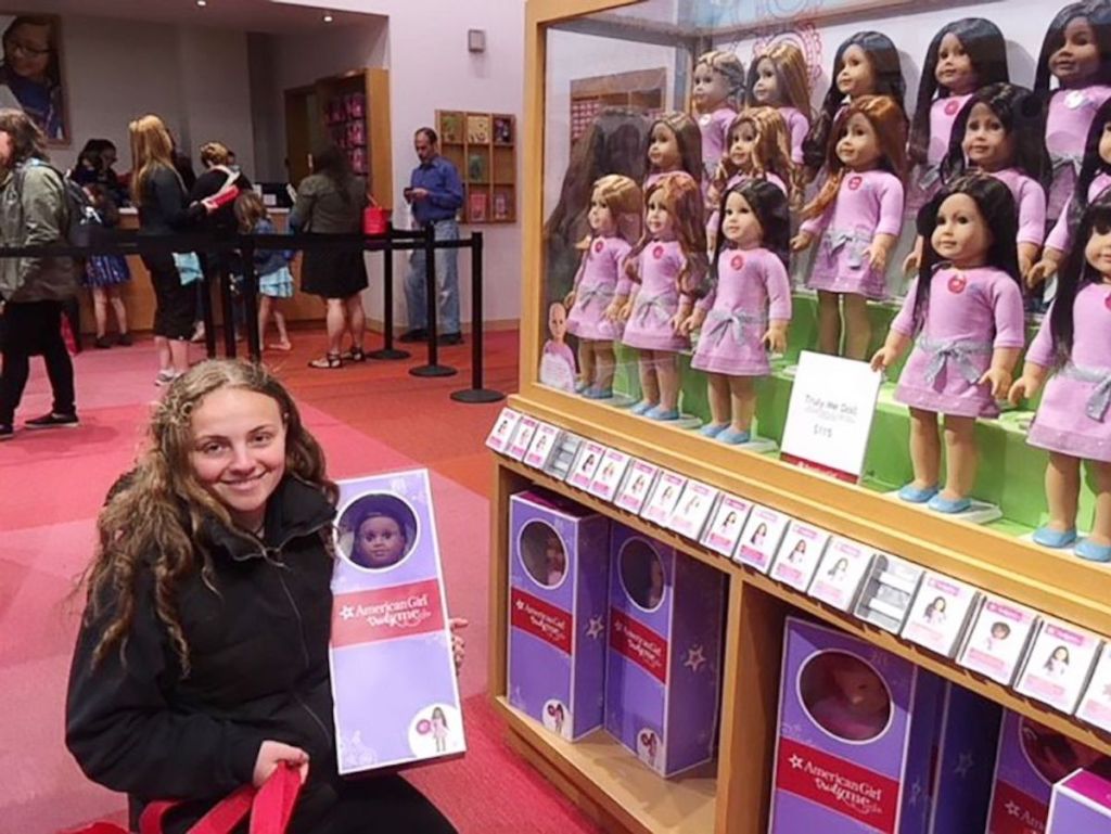 girl sitting with american girl dolls