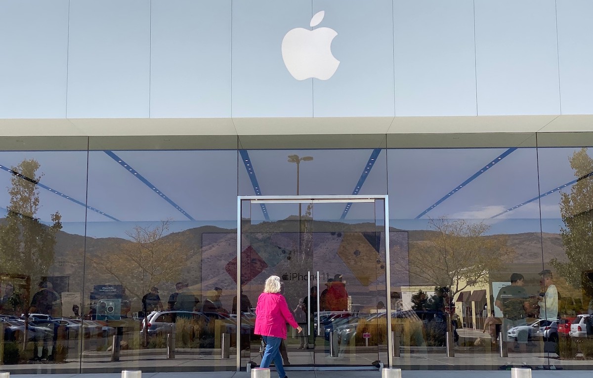 woman walking into apple store front outside to get a teacher discount