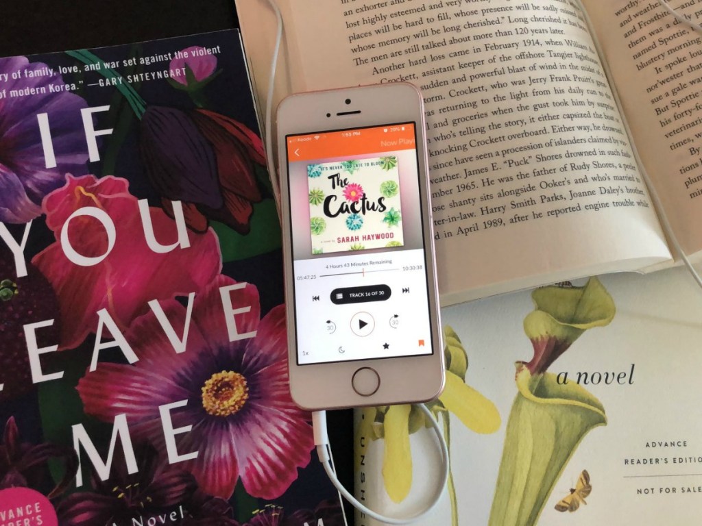 phone with audiobook playing surrounded by actual books