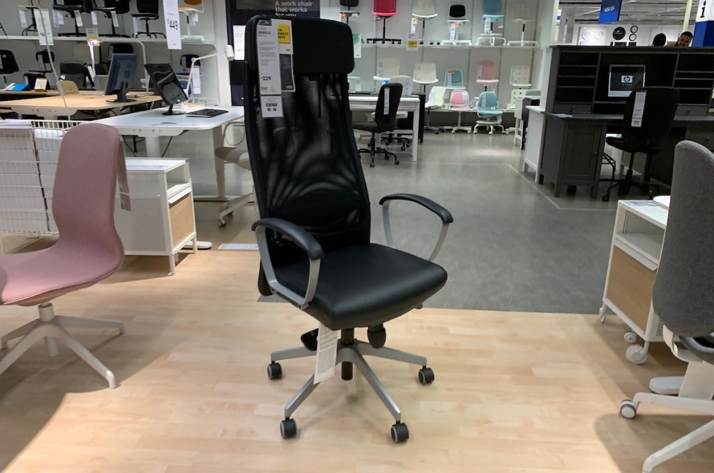 Tall black office chair sitting on wood floor 