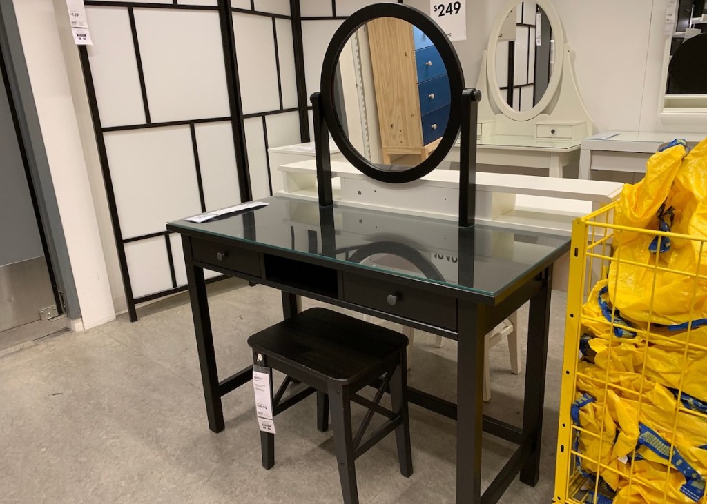 black makeup vanity with round mirror and stool in IKEA store