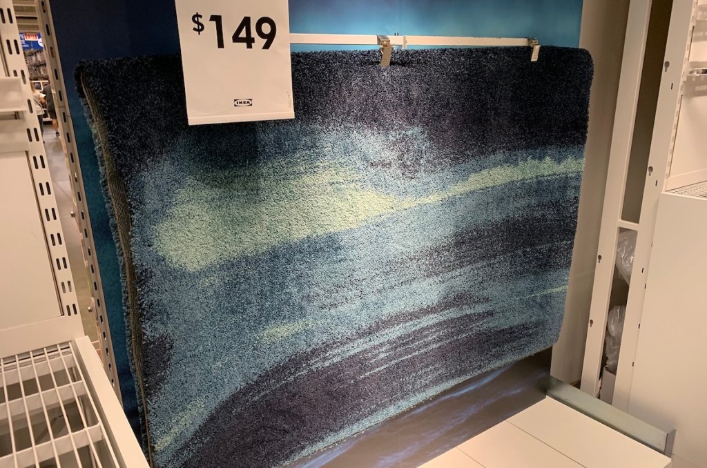 blue rug hanging on store wall 