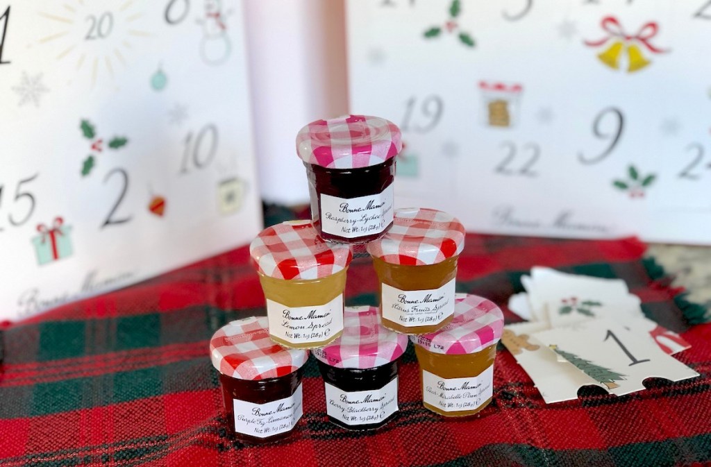 stack of mini jelly jars on christmas towel with advent calendar in background