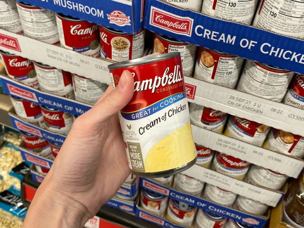 hand holding can of soup near store display