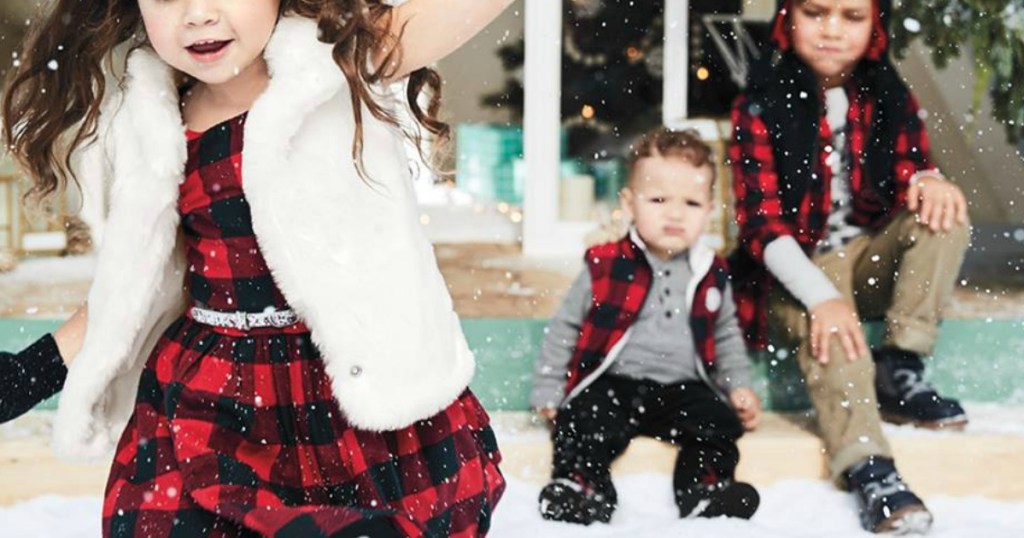 little kids wearing christmas outfits in snow