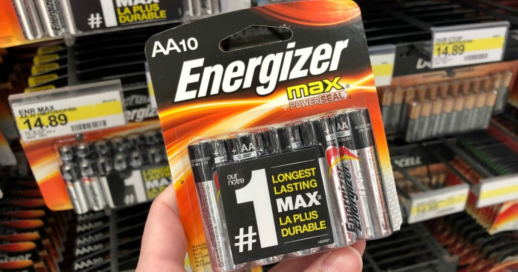 hand holding up pack of batteries by store display