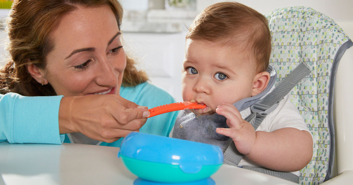 mom feeding baby with first years take and toss flatware