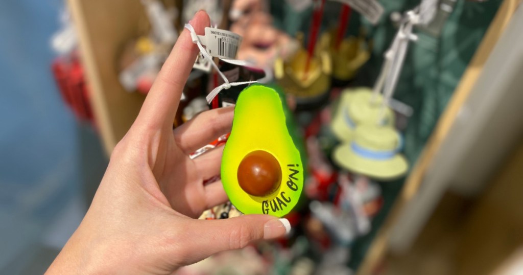 hand holding up guac on ornament and blurred background