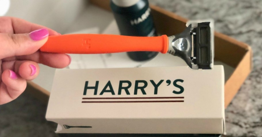 hand holding razor over box on counter