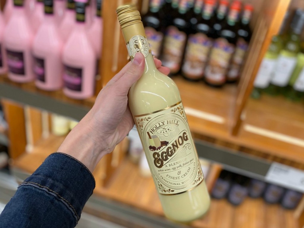hand holding bottle of wine by store display