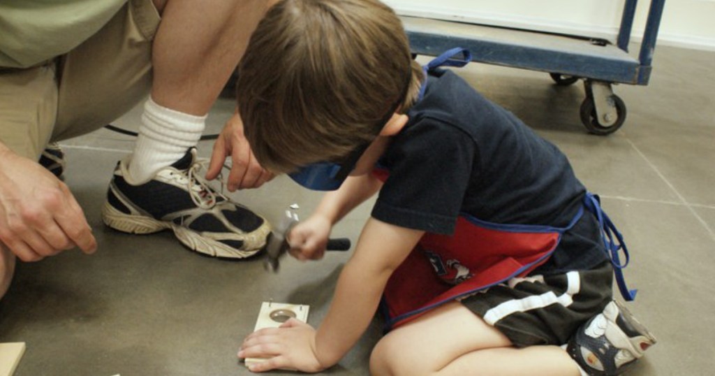 kid with hammer at store building a project