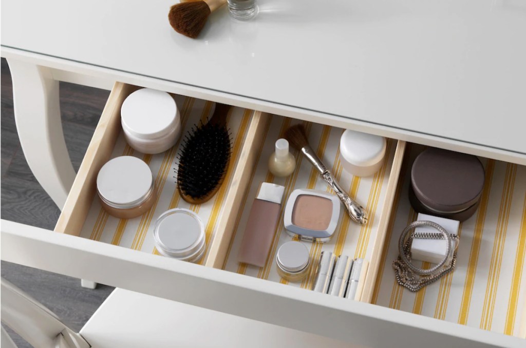 makeup drawer filled with brush and jars of stuff
