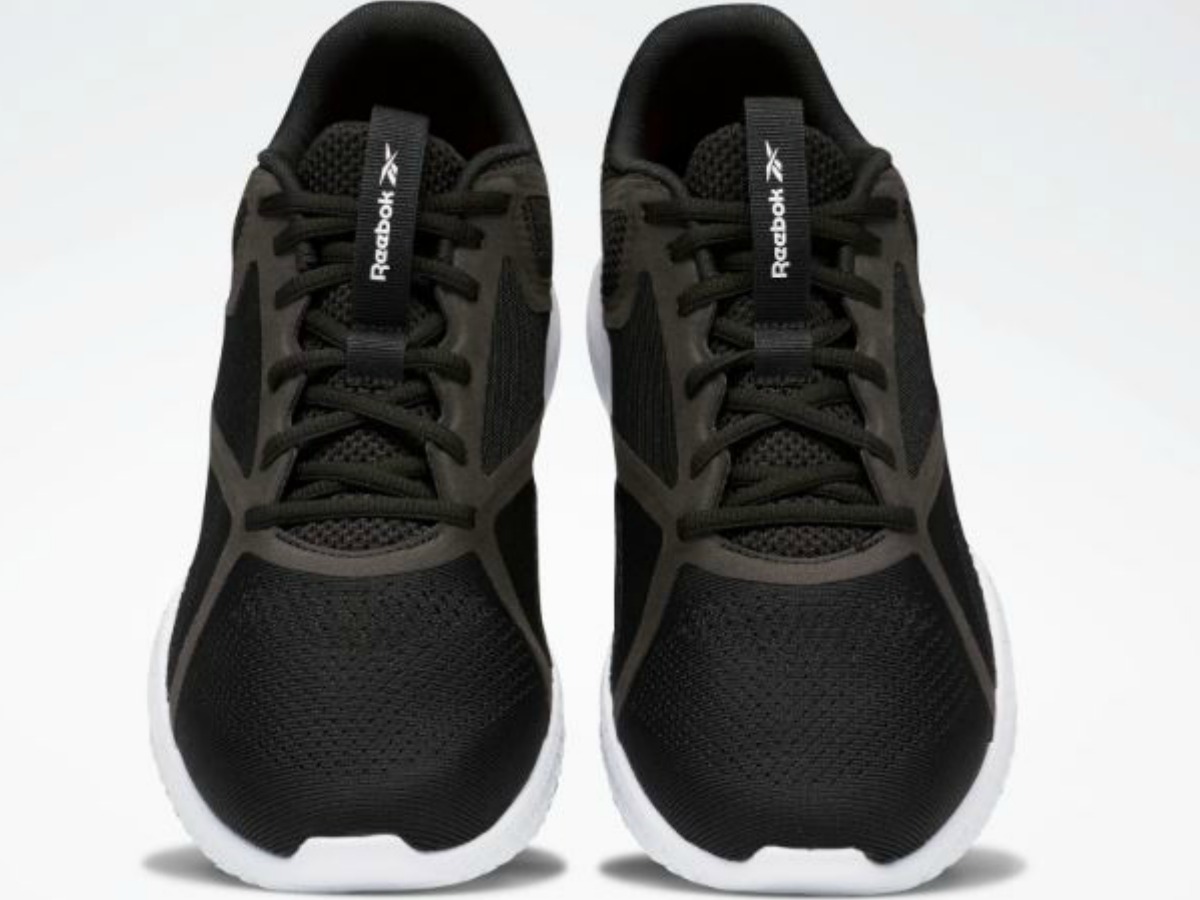 black pair of tennis shoes on white background