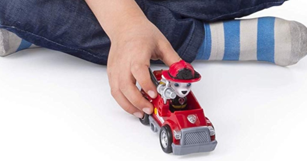 hand playing with paw patrol figure