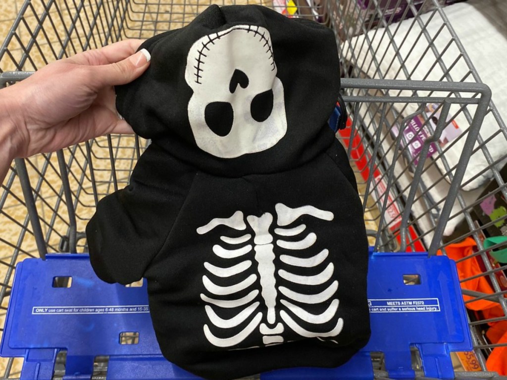 hand holding little skeleton pet hoodie in shopping cart