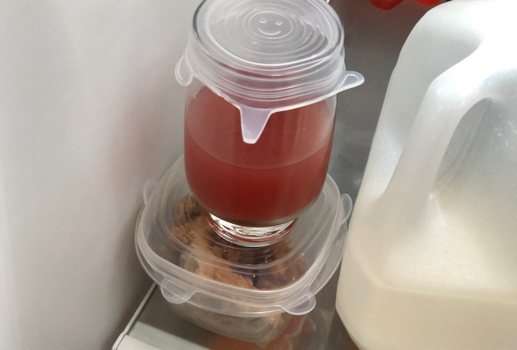 drink sitting on tupperware of chicken with silicone lids