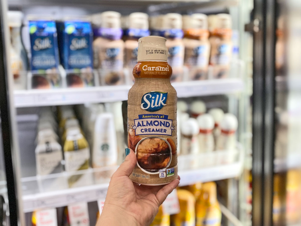 hand holding silk almond coffee creamer in target by refrigerator