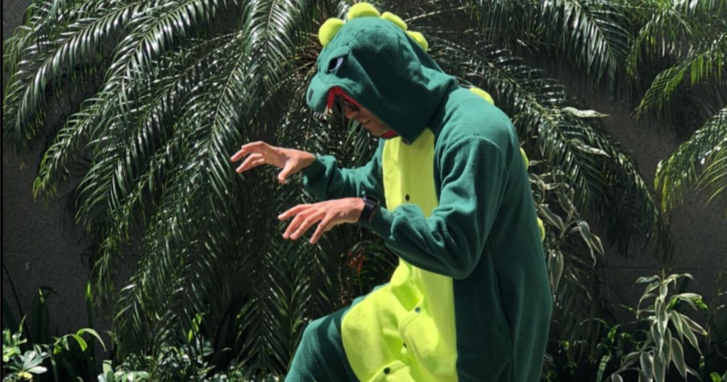 man in dino costume with trees behind him