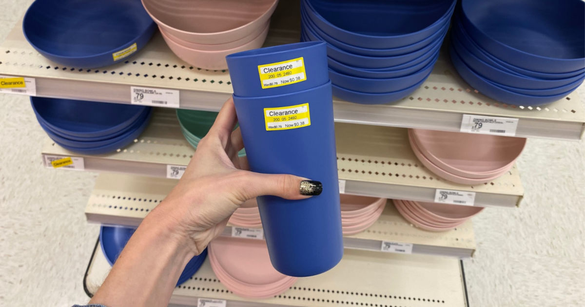 hand holding blue plastic cup in store w/ plastic bowls in background