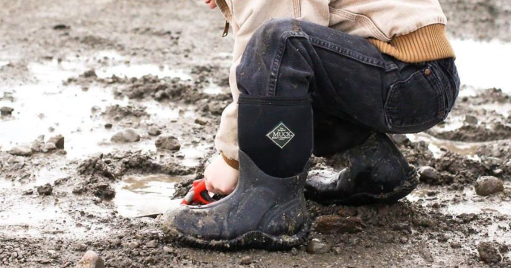 kid playing in dirt wearing muck boots