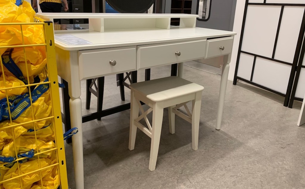 white vanity desk sitting in IKEA store with yellow bags