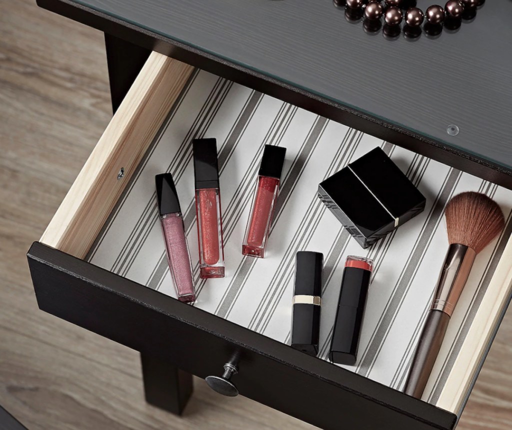 black brown vanity drawer filled with various makeup 