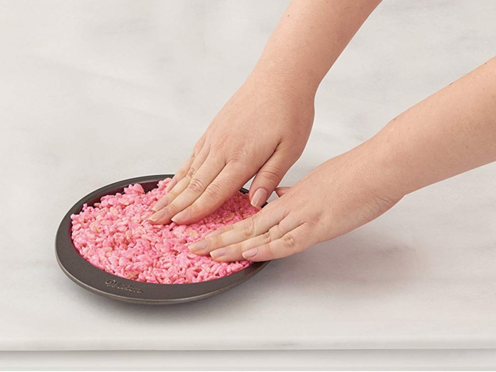 hands pressing batter into baking pan
