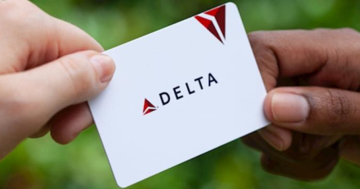 two hands holding Delta gift cards